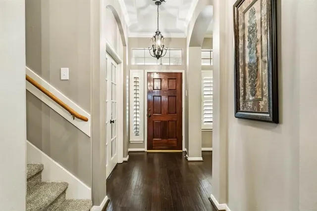 a view of a hallway with wooden floor and staircase