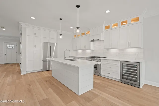 a kitchen with white cabinets and stainless steel appliances