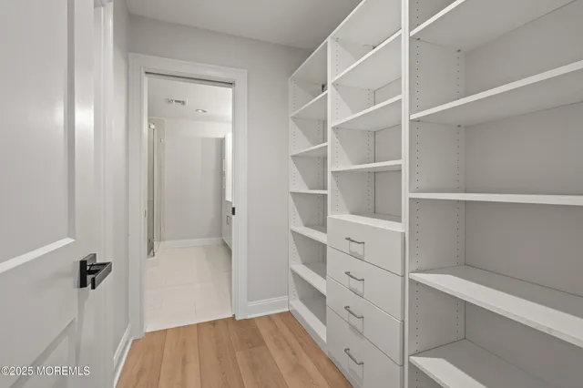 a view of walk in closet with empty racks