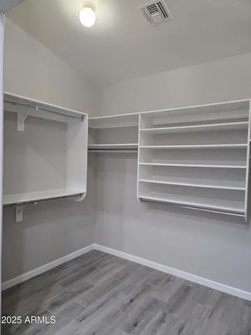 a view of walk in closet with empty racks