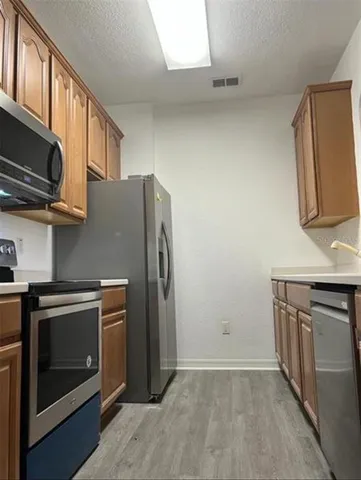 a kitchen with stainless steel appliances granite countertop a refrigerator stove and sink