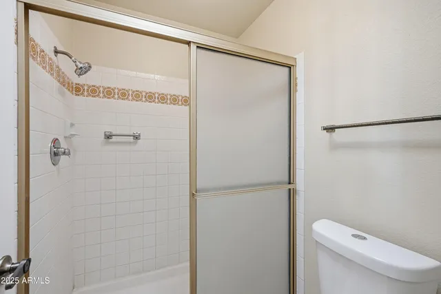 a bathroom with a granite countertop shower and a toilet