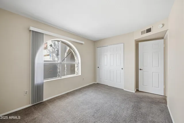 an empty room with a large window and wooden floor