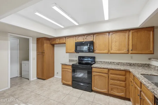 a kitchen with granite countertop cabinets stainless steel appliances and a counter space