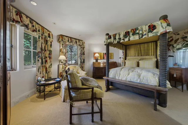 a bedroom with furniture and a large window