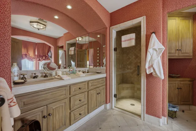 a spacious bathroom with a shower sink and mirror