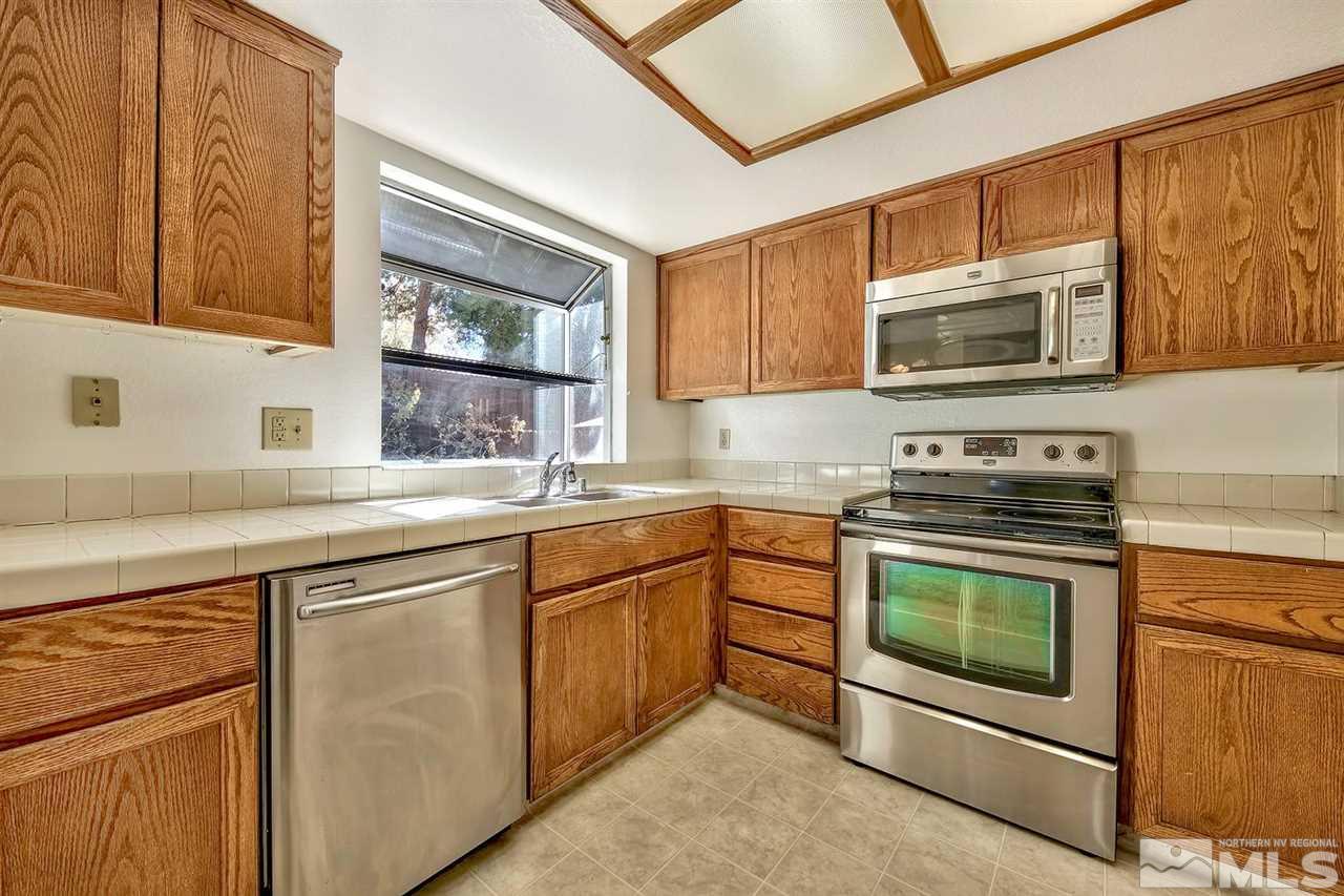 2702 Caballo Drive Reno, NV 89502 - Photo 9 of 17 a kitchen with stainless steel appliances granite countertop a stove microwave and sink