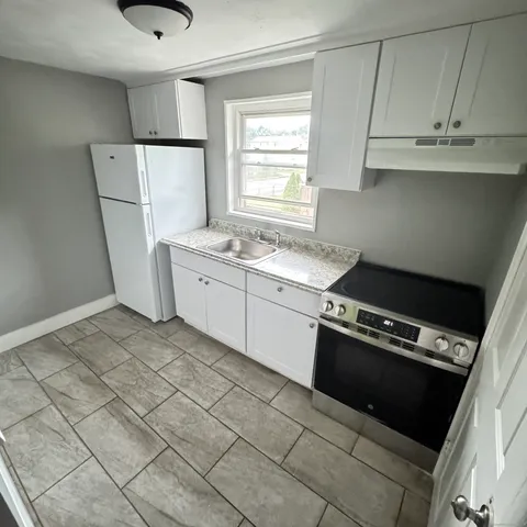 a kitchen with a stove a refrigerator and a sink