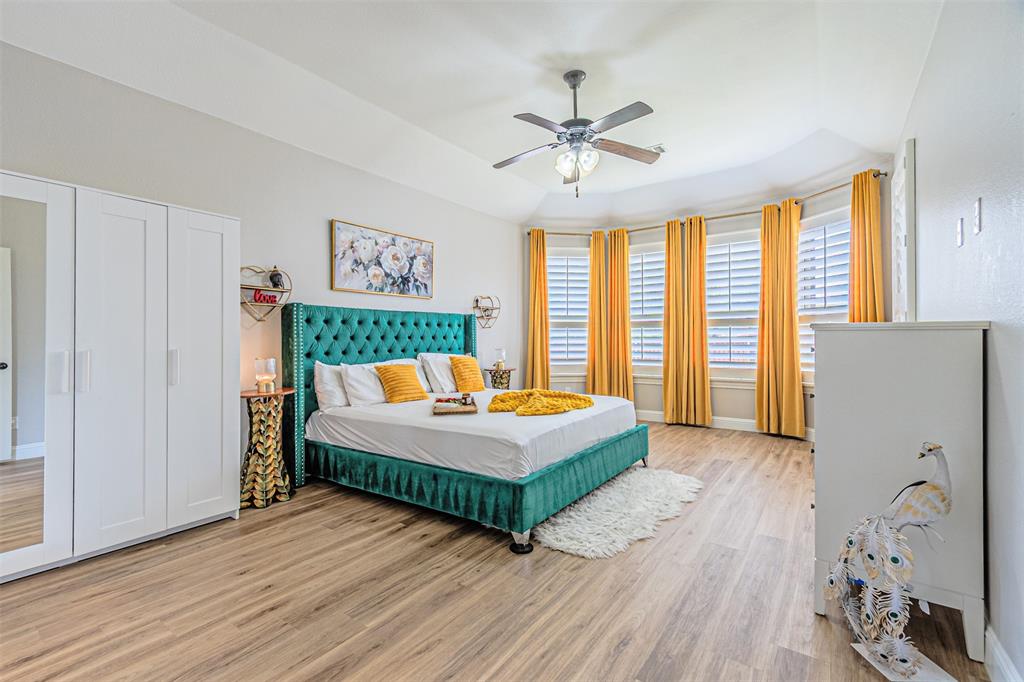 1805 Stetson Way Allen, TX 75002 - Photo 9 of 22 Spacious room featuring wood-finish flooring, a tray ceiling, and a ceiling fan with integrated lighting