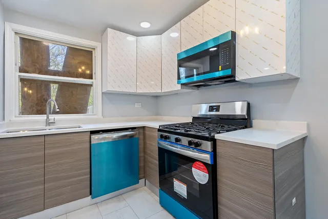 a kitchen with stainless steel appliances granite countertop a stove a sink and a microwave