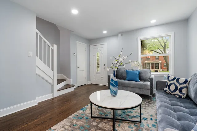 a living room with furniture and a wooden floor