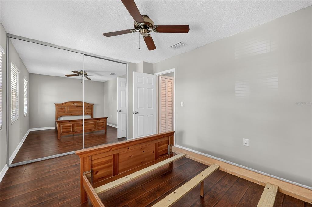 2464 Enterprise Road, Unit 3 Clearwater, FL 33763 - Photo 19 of 29 a room with wooden floor and ceiling fan