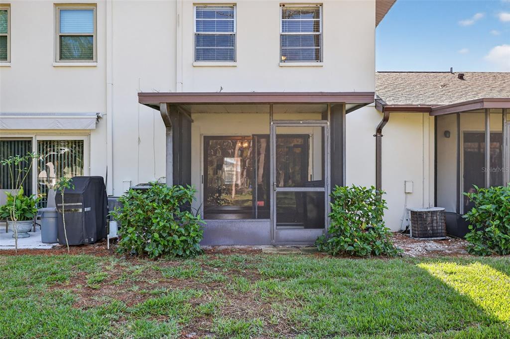 2464 Enterprise Road, Unit 3 Clearwater, FL 33763 - Photo 25 of 29 a view of a house with potted plants and a table