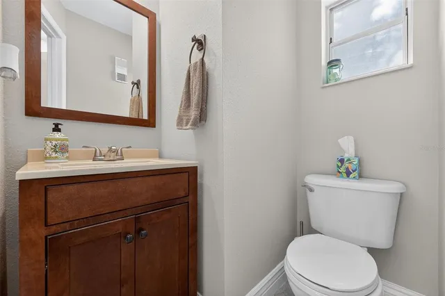 a bathroom with a toilet sink vanity and mirror