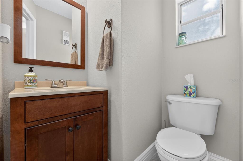 2464 Enterprise Road, Unit 3 Clearwater, FL 33763 - Photo 6 of 29 a bathroom with a toilet sink vanity and mirror