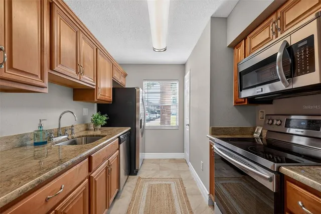 a kitchen with stainless steel appliances granite countertop a sink stove and cabinets
