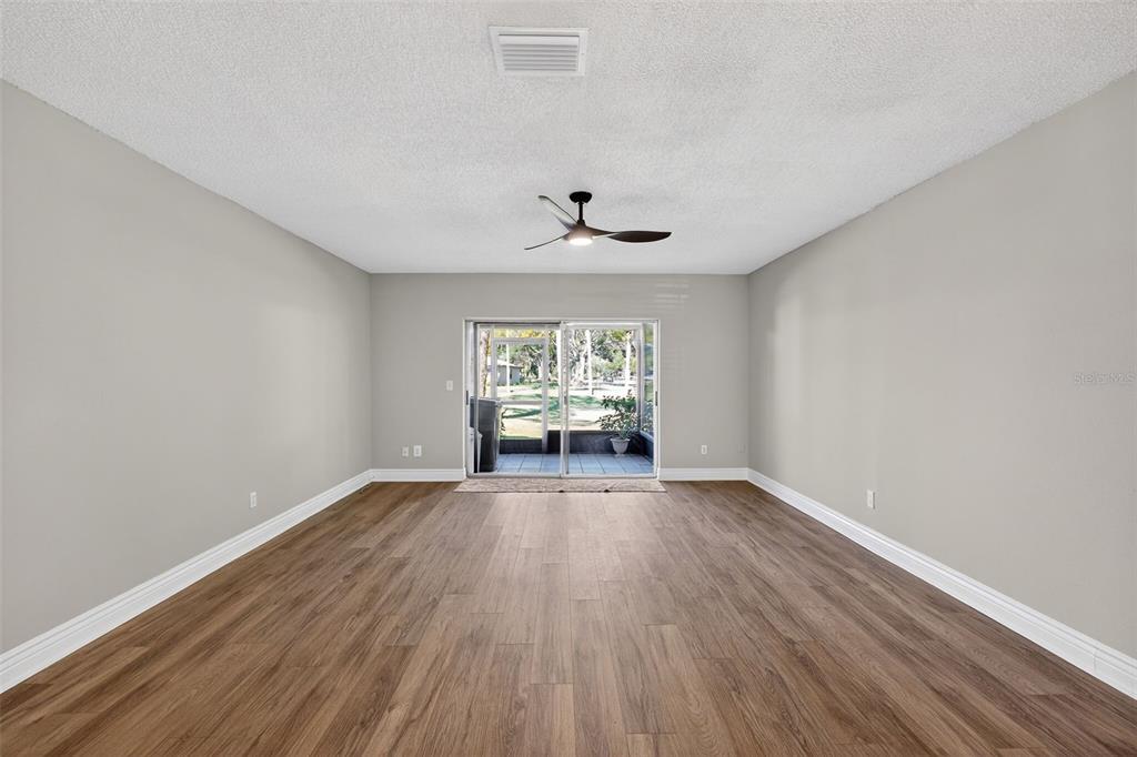 2464 Enterprise Road, Unit 3 Clearwater, FL 33763 - Photo 9 of 29 a view of an empty room with wooden floor and a window