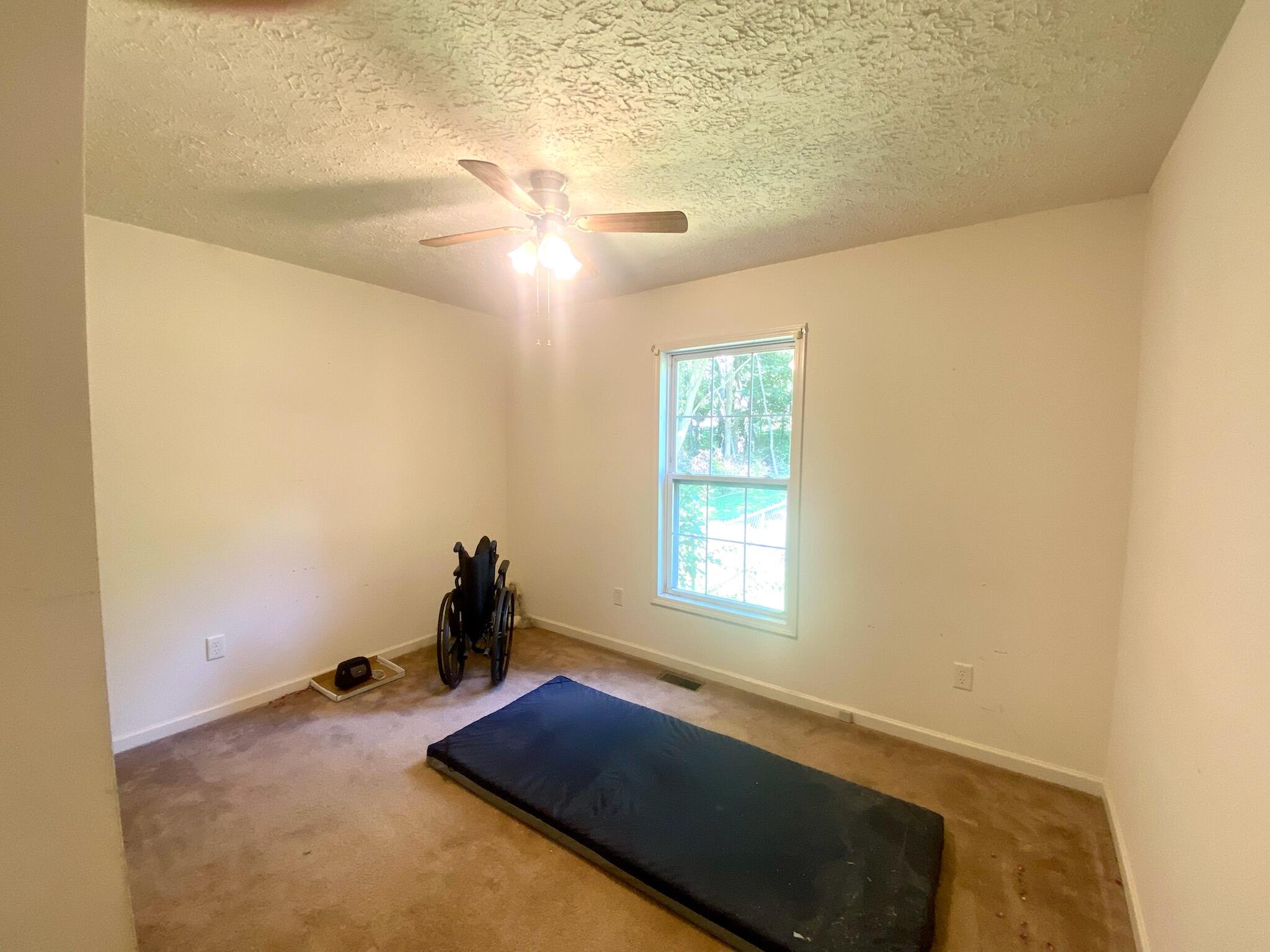 1321 Mitchell Road Axton, VA 24054 - Photo 22 of 31 a bedroom with a bed and a chandelier fan