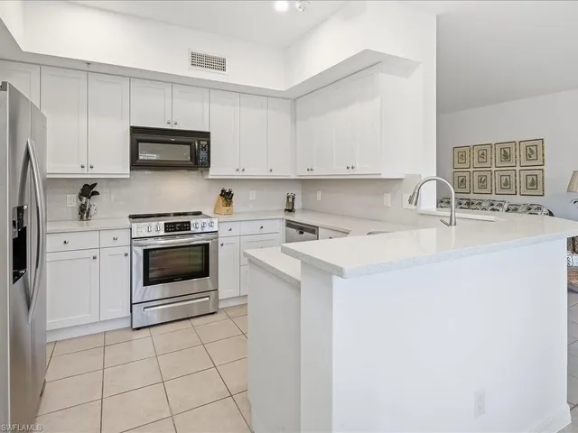 a kitchen with appliances a sink and cabinets