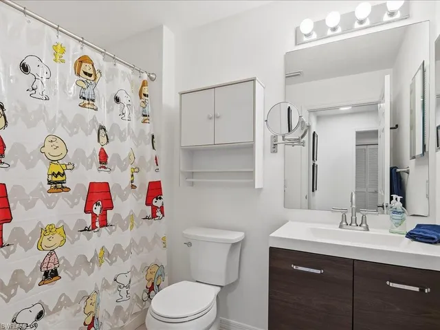 a bathroom with a sink mirror vanity and toilet