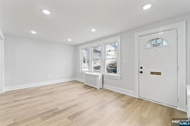 an empty room with wooden floor and window