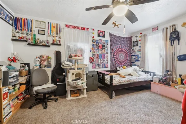 a bedroom with furniture and a fan