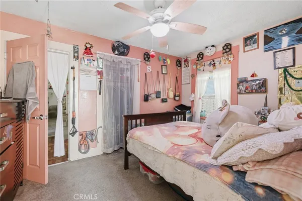 a bedroom with a bed couch and a large mirror