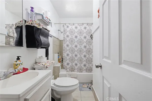 a bathroom with a sink a toilet and shower curtain