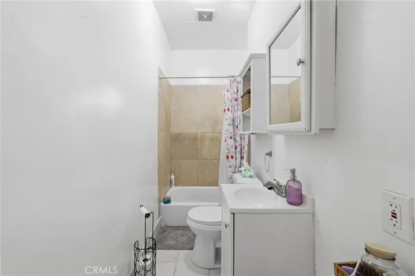 a bathroom with a sink a toilet and shower curtain