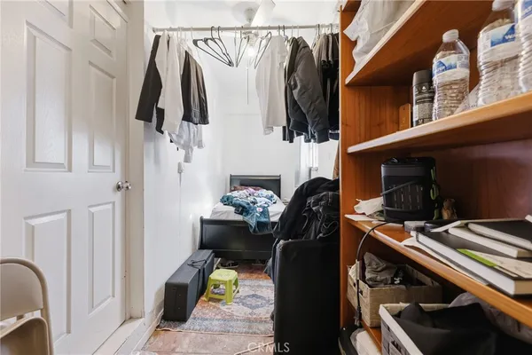 a view of walk in closet with clothes and shoes