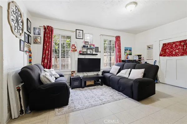 a living room with furniture a flat screen tv and a window