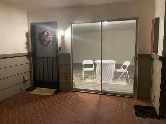 a view of an empty room with wooden floor and a bathroom