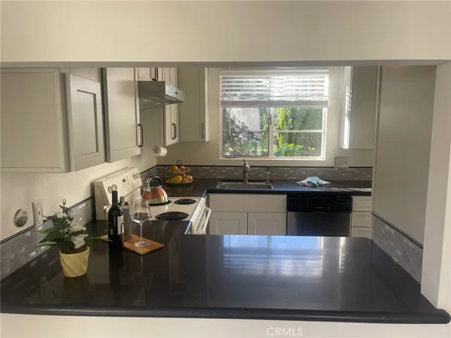 a kitchen with a large counter top sink and stove