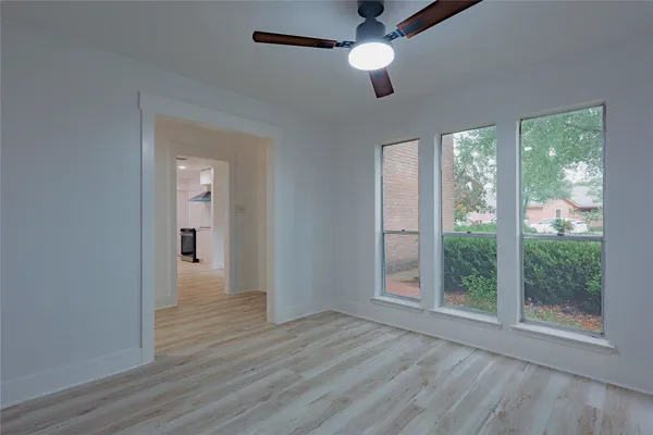 a view of a room with wooden floor and fan
