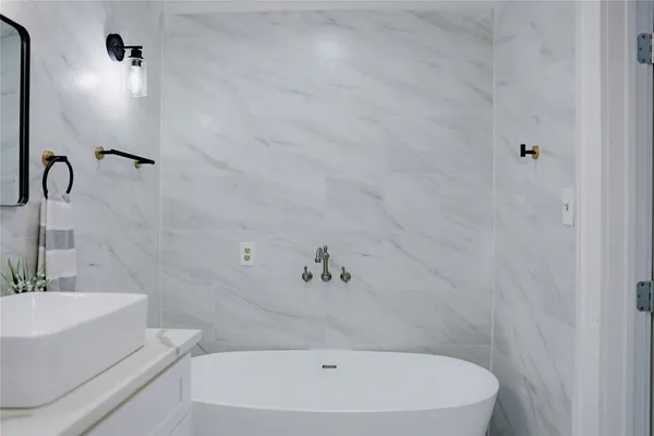 a bathroom with a sink a mirror and a potted plant