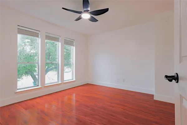 a view of empty room with wooden floor