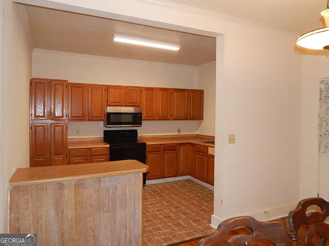 a kitchen with granite countertop a stove and a wooden cabinets