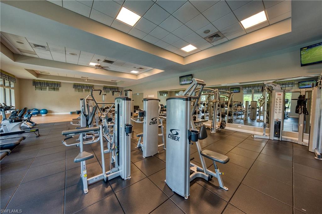 4374 Bismark Way Naples, FL 34119 - Photo 46 of 49 Fitness center featuring extensive weight training equipment, cardio machines, rubberized flooring, and multiple ceiling-mounted televisions