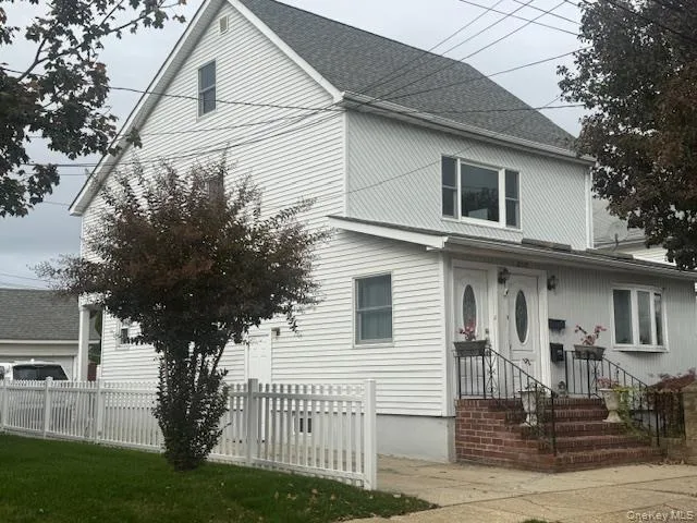 a front view of a house with a tree