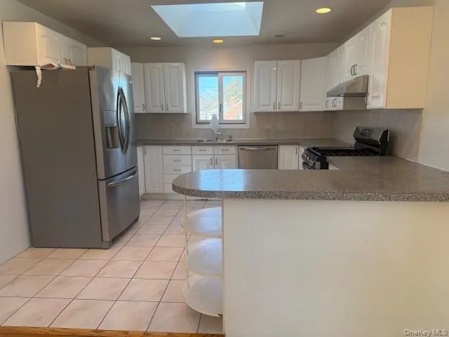 a kitchen with stainless steel appliances granite countertop a refrigerator a stove a sink and a granite counter tops