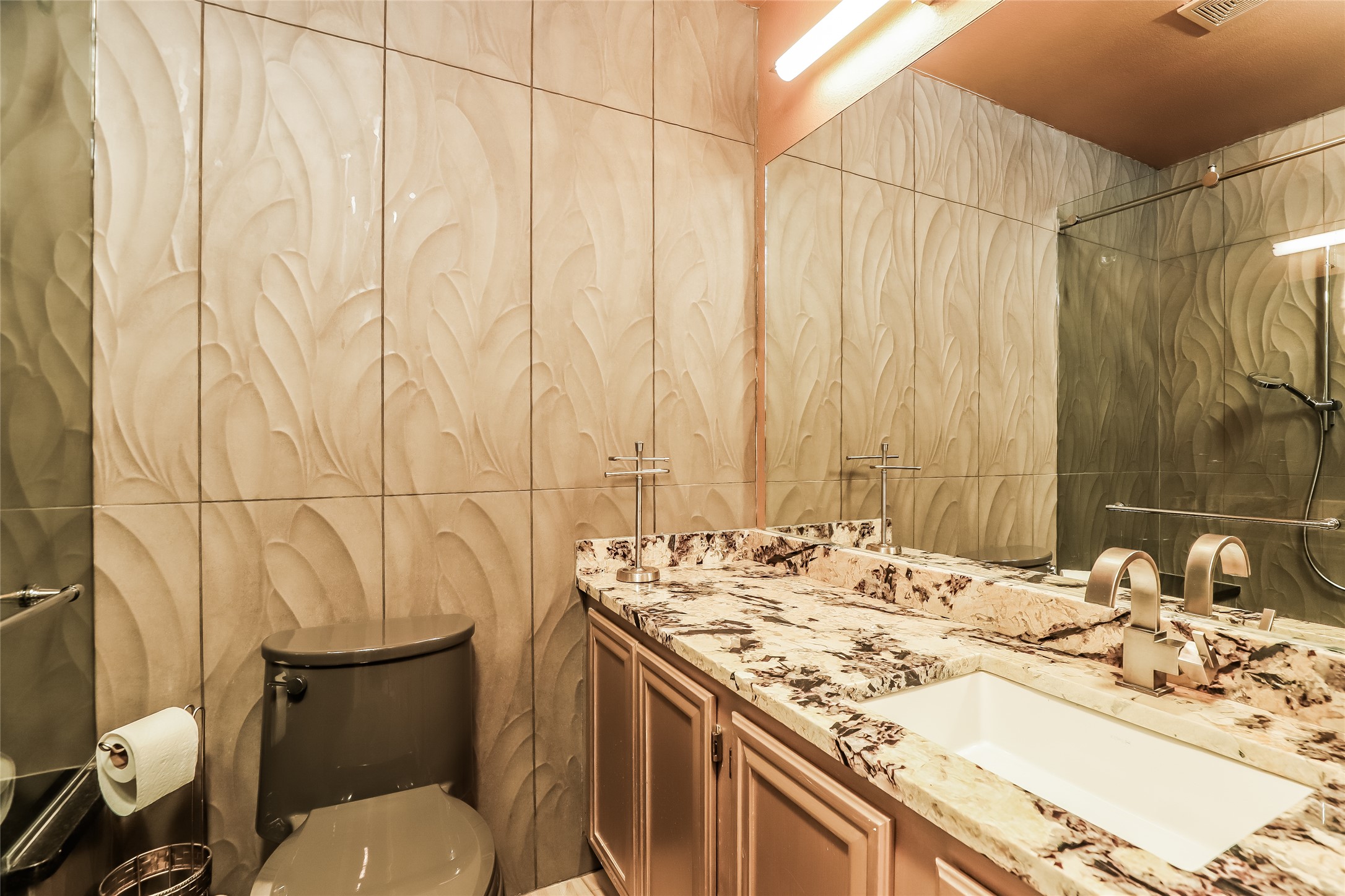 1702 Newning Avenue, Unit A Austin, TX 78704 - Photo 15 of 20 Bathroom featuring textured wall tiles, a vanity with a granite countertop, an undermount sink, and brushed nickel faucets