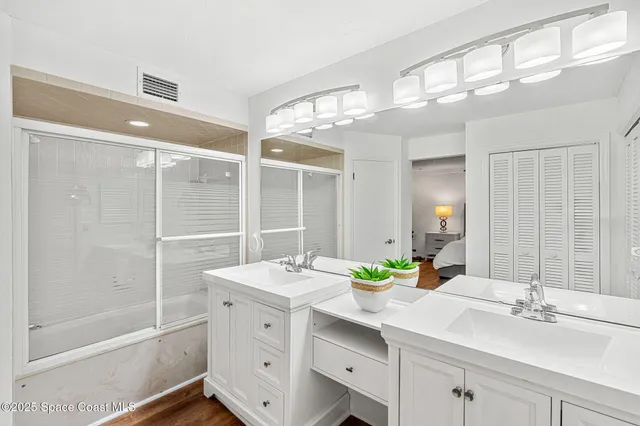 a bathroom with a double vanity sink mirror and shower