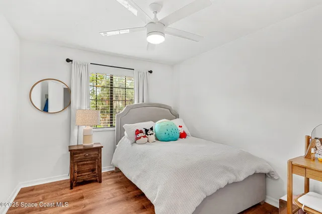 a bedroom with a bed a dresser and a large window