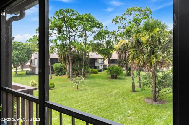 a front view of a house with garden and trees