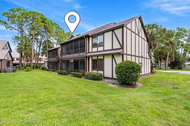 an aerial view of residential houses with outdoor space and trees