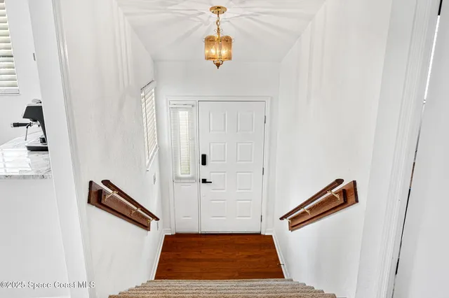 a hallway with front door wooden floor and windows