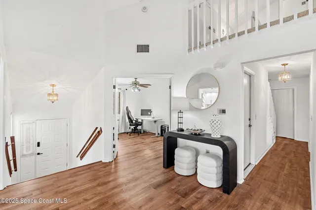 a living room with furniture a mirror and a wooden floor