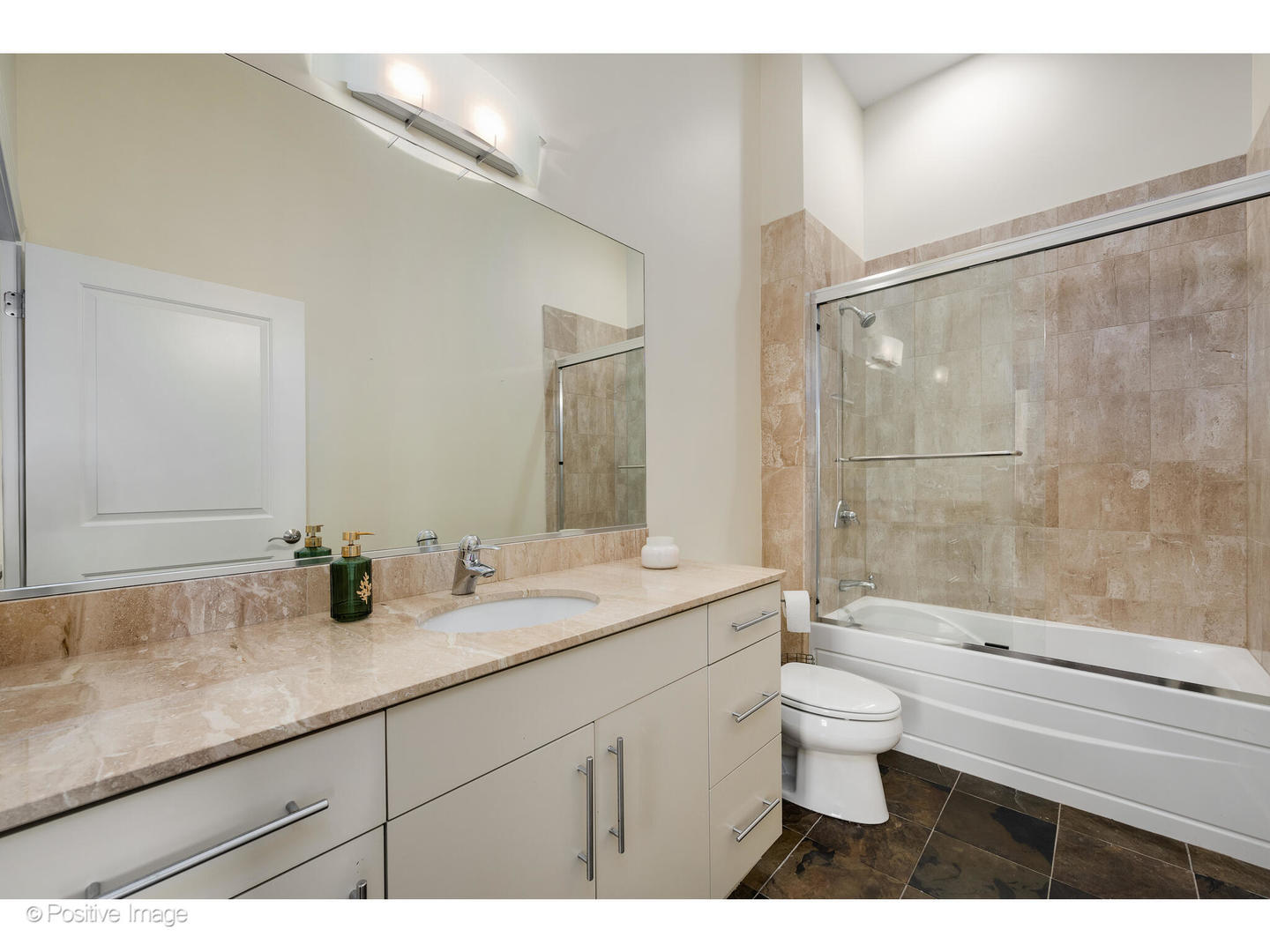955 West Monroe Street, Unit 4A Chicago, IL 60607 - Photo 19 of 24 a bathroom with a granite countertop sink a toilet a mirror and shower