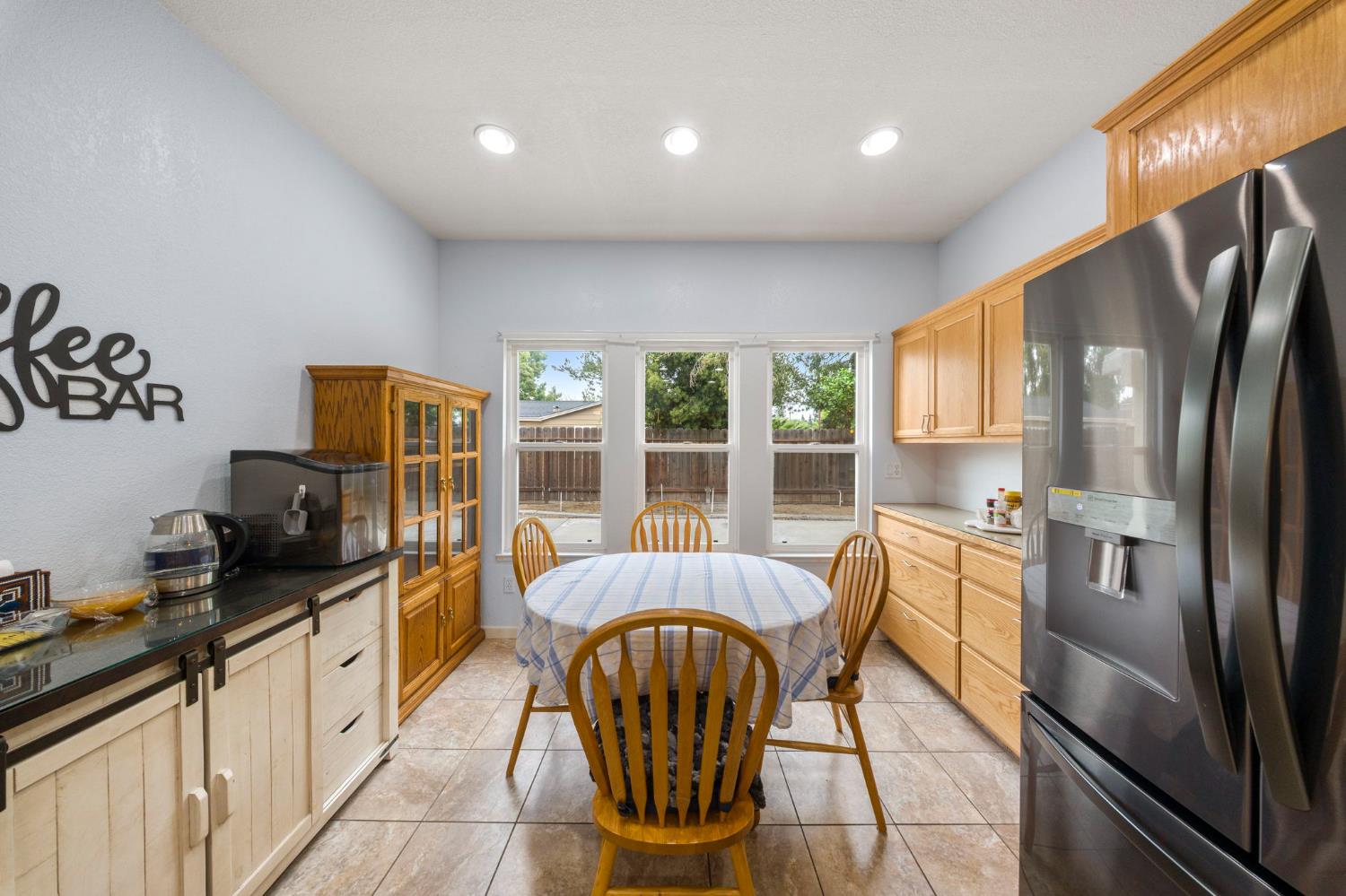 2101 Arabian Way Turlock, CA 95380 - Photo 20 of 38 a kitchen with stainless steel appliances granite countertop a refrigerator a stove a sink dishwasher a dining table and chairs with wooden floor