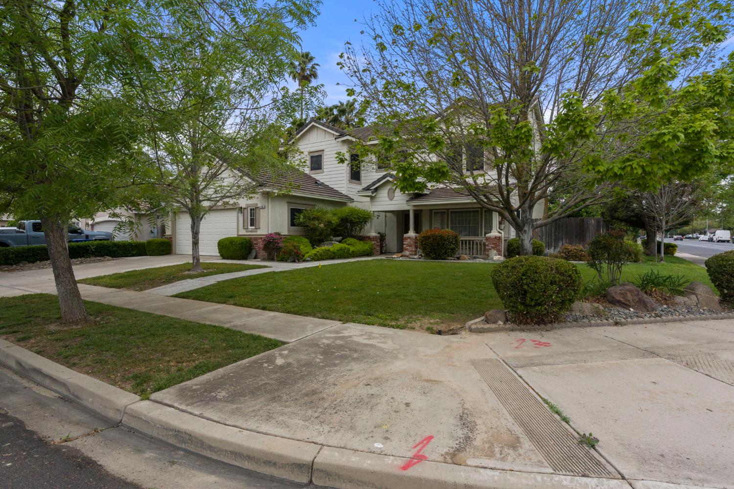 2101 Arabian Way Turlock, CA 95380 - Photo 2 of 38 a view of a white house next to a yard with big trees